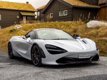 郊外の住宅前に停まる白いマクラーレンのスポーツカー